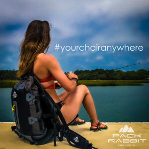 Girl sitting in black backpack seat on dock fishing