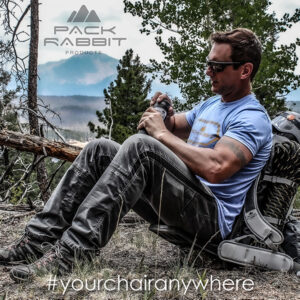 Hiker sitting in backpack seat taking a drink in woods