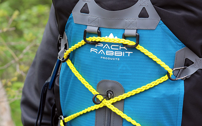 Close up of yellow bungie cord on blue backpack